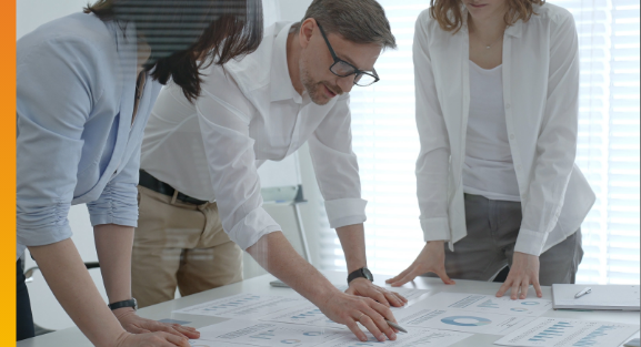Business professionals reviewing financial reports and charts together during a meeting.